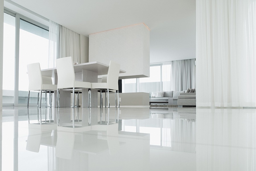 This image shows a dining and living room with a white epoxy floor.